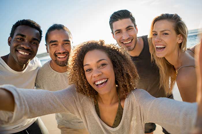 Smiling Group of friends taking selfie outdoors at the beach